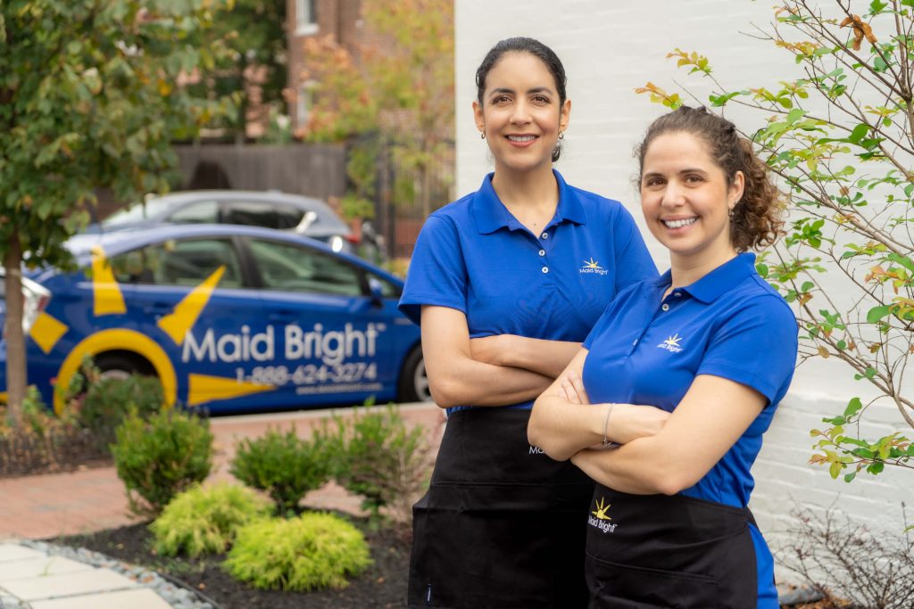 Maid Bright cleaning staff standing in front of Maid Bright car