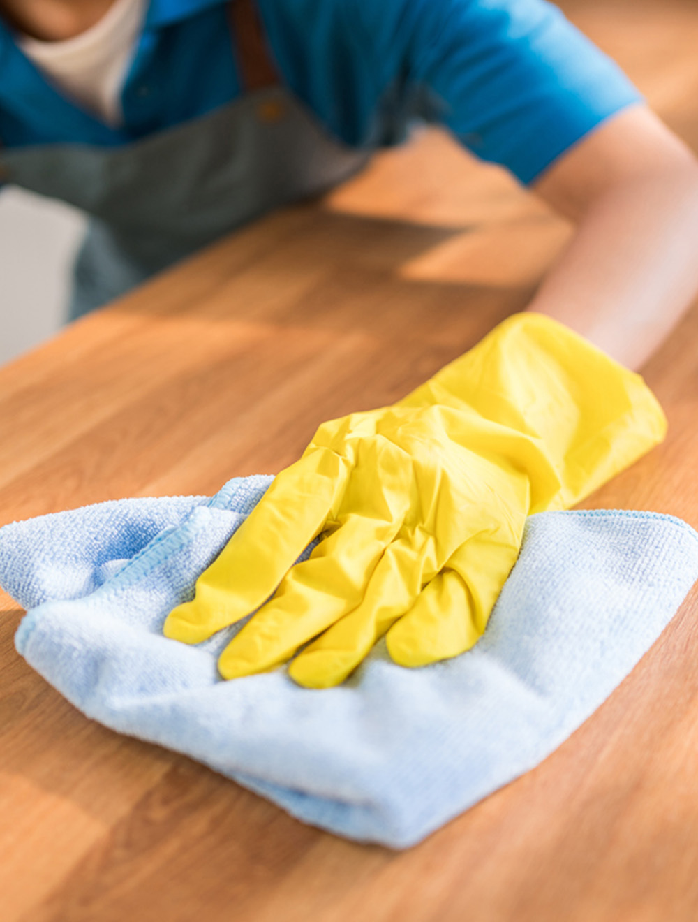 maid cleaning surface of table