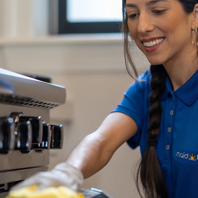 Maid Bright cleaning a stove in a home