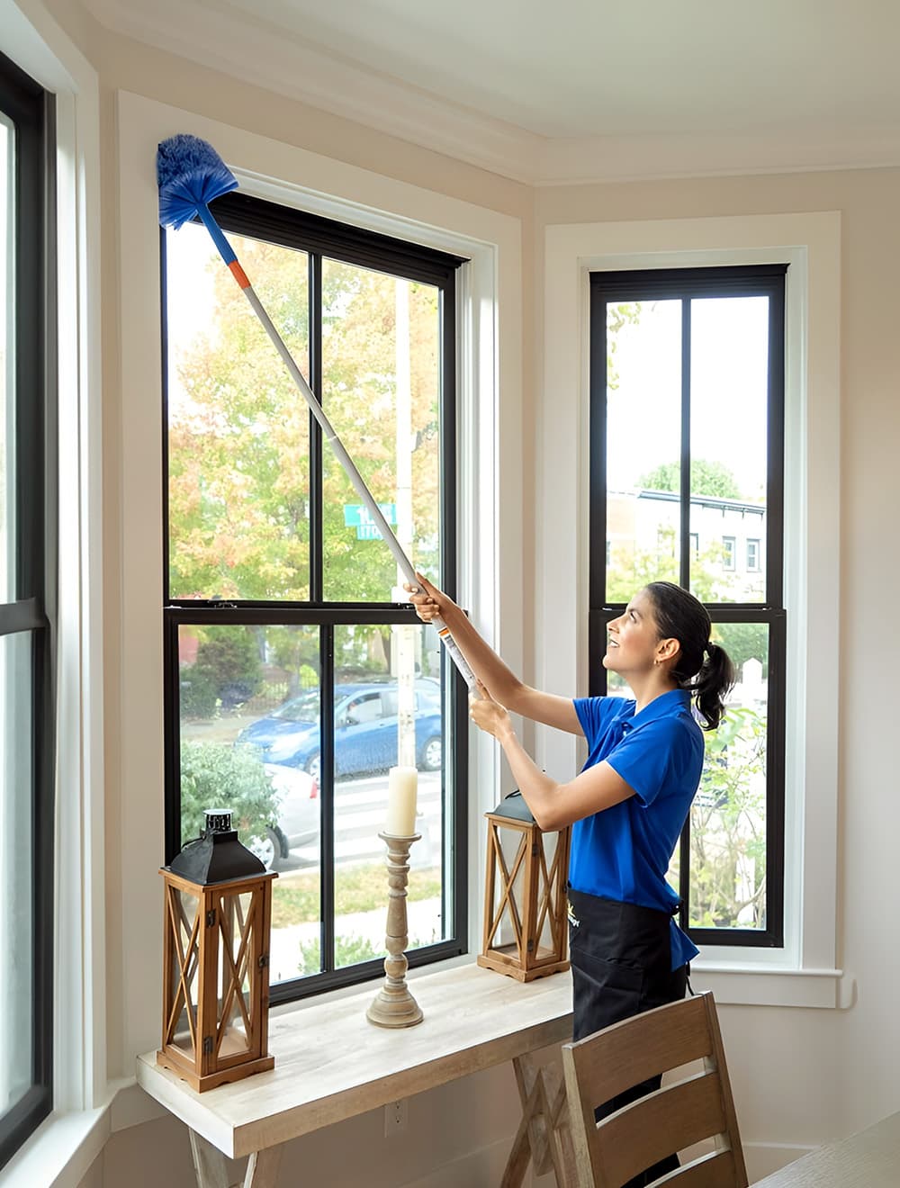 professional maid from Maid Bright dusting above windows