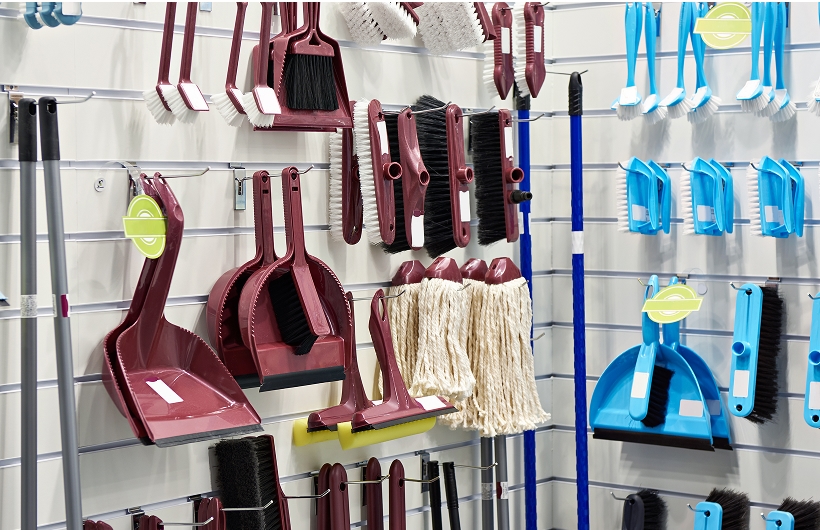 dust pans and brooms on a shelf