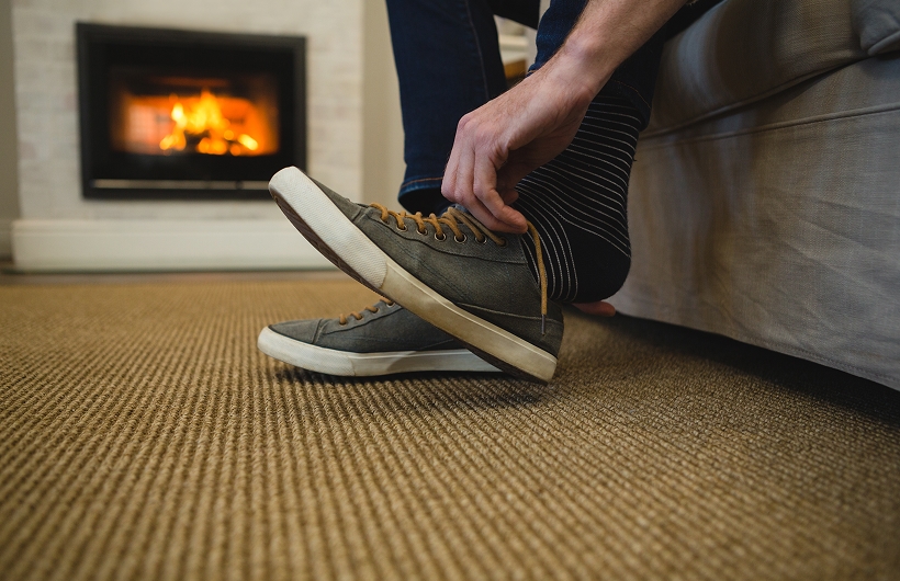 man putting shoes on inside the house