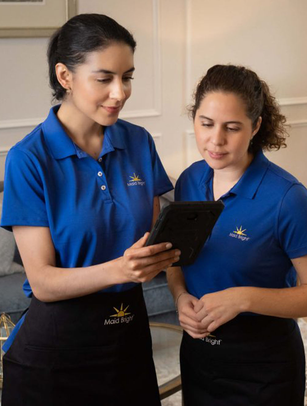 Maid Bright cleaning team looking at tablet