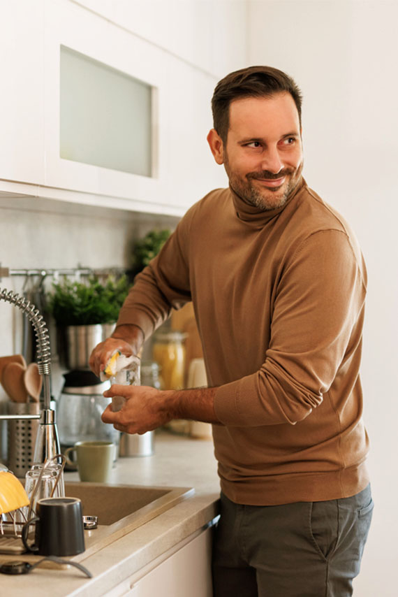 man cleaning dishes in the sink